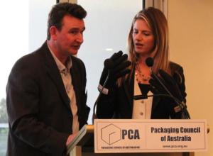 Fergal Barry (left) of Arthritis Australia gets Julia Zemiro to try on 'Arthritis Gloves' designed to simulate the difficulty arthritis sufferers have in opening packaging. Arthritis Australia sponsored the Accessibility award.